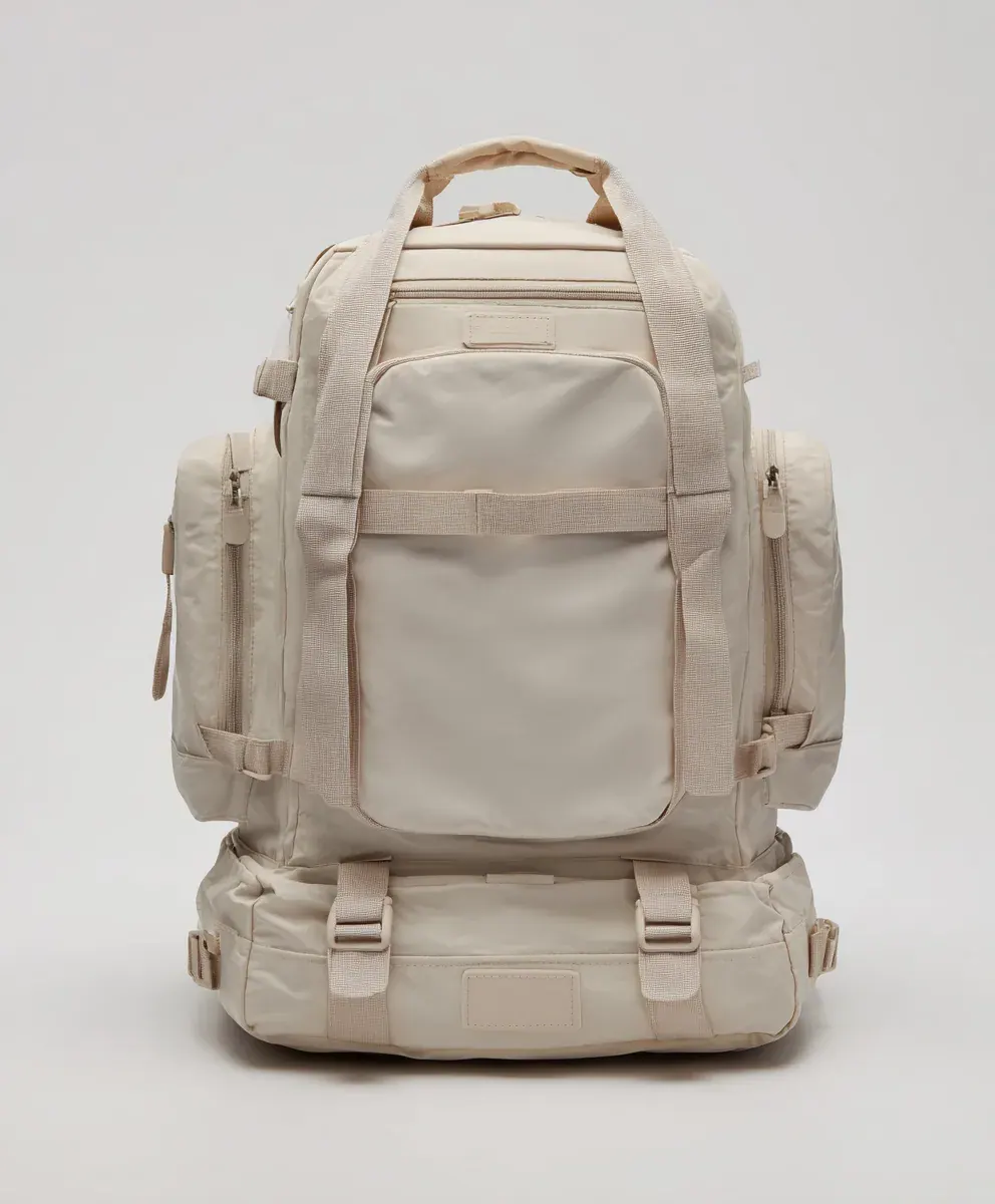 Waterproof backpack laid flat for inspection with a small puncture and seam edge marked for measurement