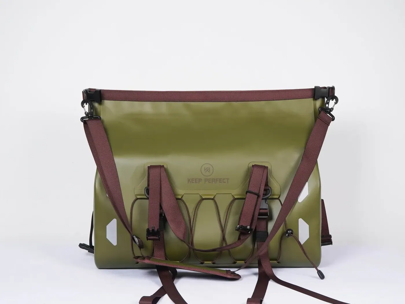 Loaded waterproof dry backpack with rolled top and compression straps carried on a wet riverbank trail