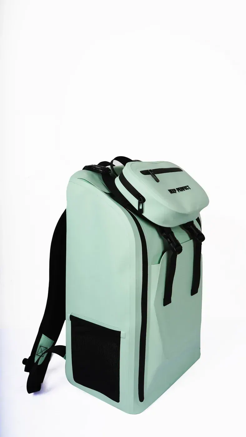 Compact roll-top dry backpack secured on a rider during steady rain with loose webbing contained