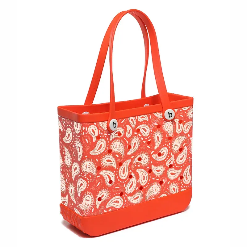 Large perforated EVA tote hung by both handles on a wall hook in a shaded garage after being rinsed and dried