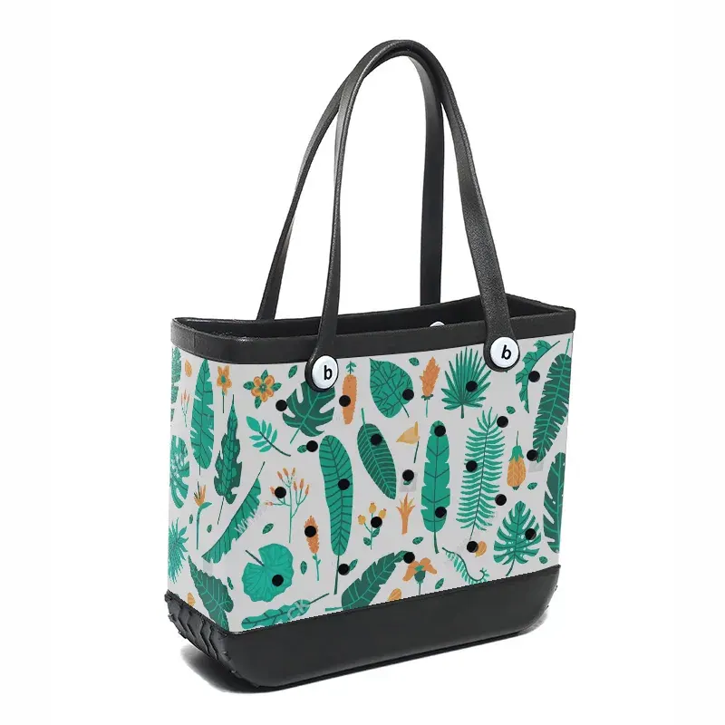 Perforated EVA tote packed for a beach day standing on damp sand with water draining through the open holes