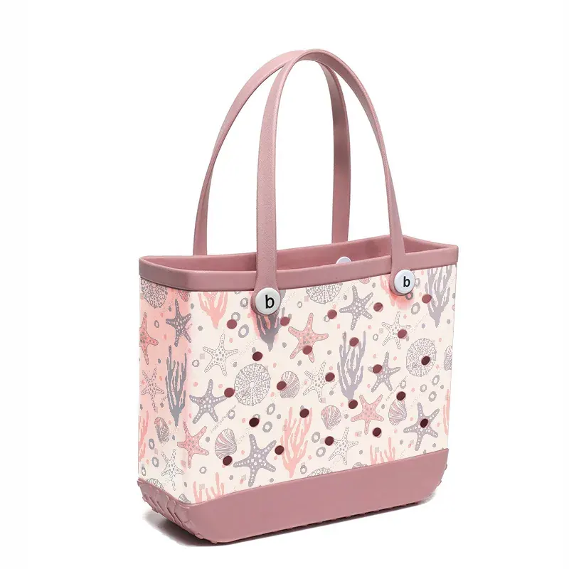 Ten perforated EVA beach totes of varying sizes and colours arranged for comparison on a pale deck
