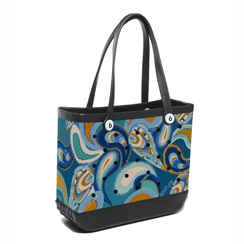 Perforated EVA tote with a wide shoulder strap and corrosion-resistant hardware shown on a wet poolside surface