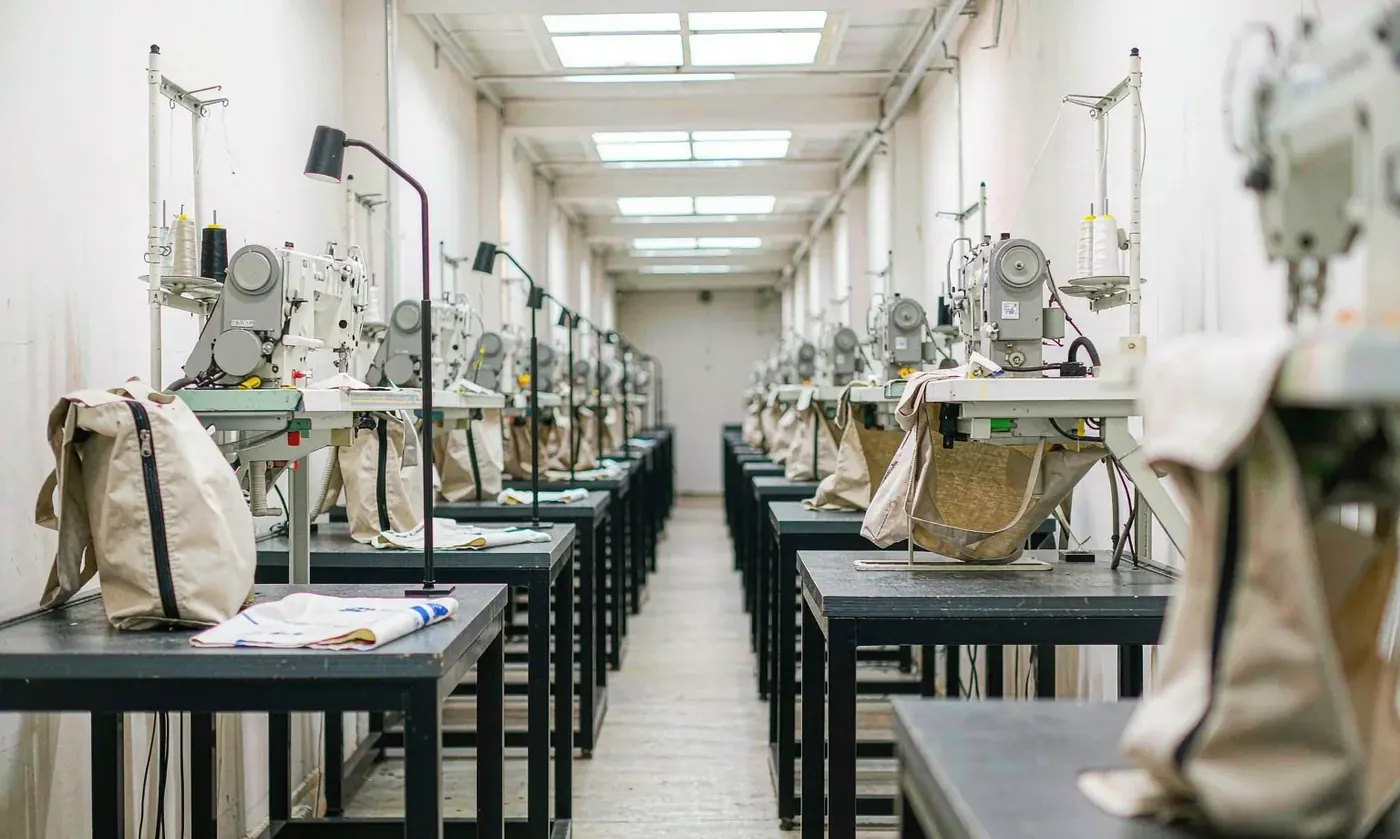 Waterproof bags arranged along an assembly bench with panels stacked before their first flex quality check