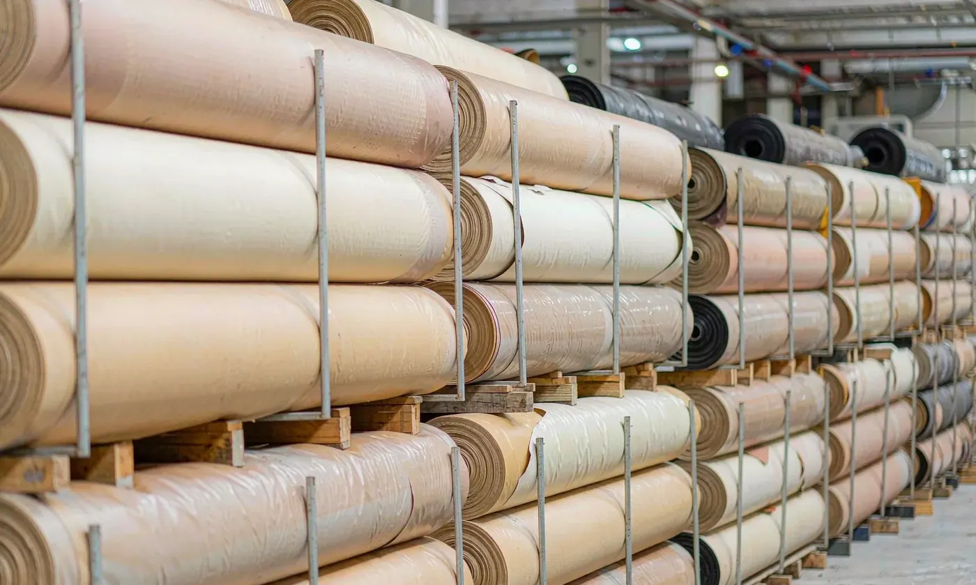 Rolls of PVC coated fabric for waterproof pack shells showing coating thickness and surface finish before cutting and welding