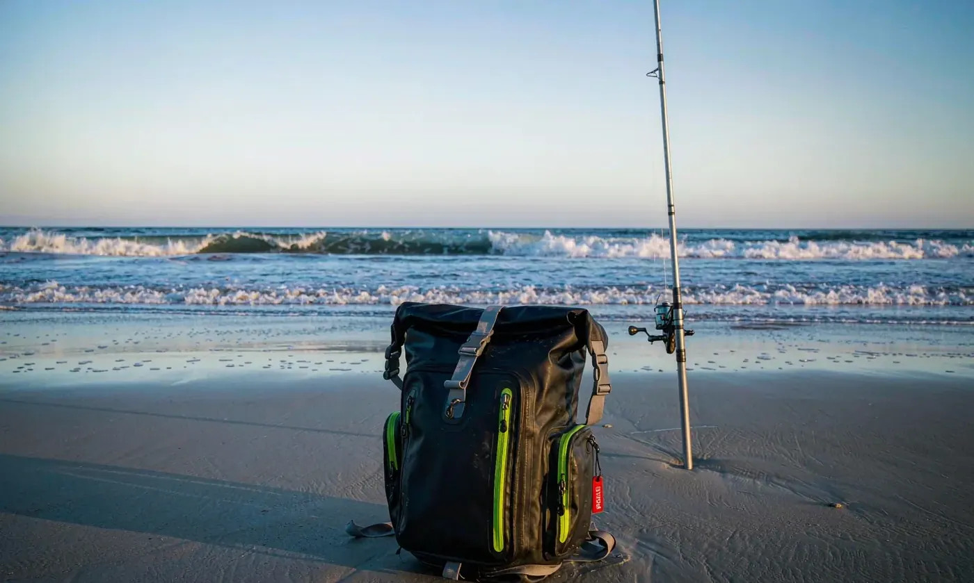 Waterproof surf casting backpack standing in shallow saltwater with welded base seams below the waterline