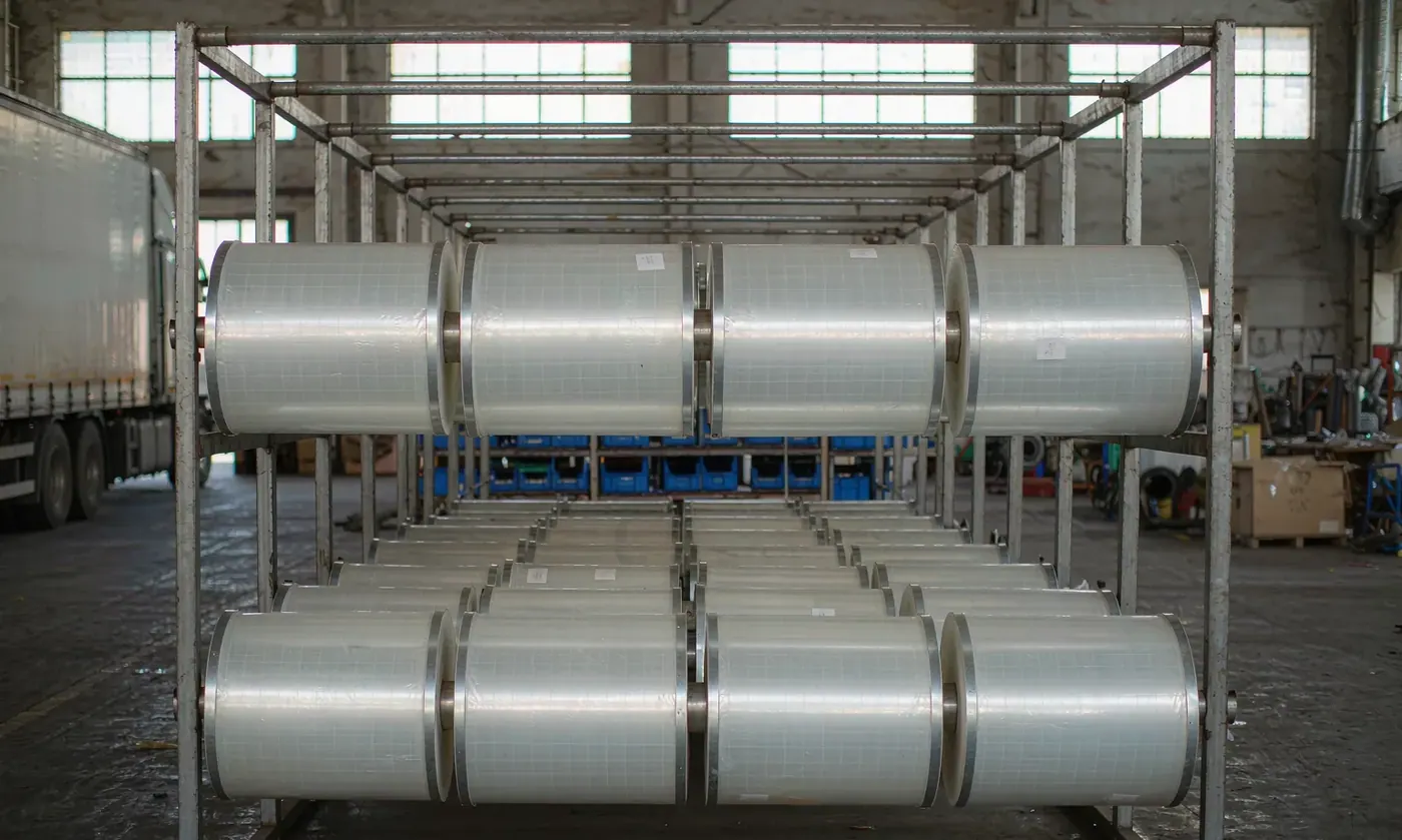 Rolls of thermoplastic polyurethane film used for waterproof pack linings stacked before lamination, showing coating thickness and surface finish
